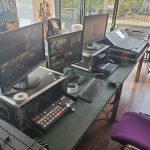 Computers and switching equipment neatly arranged on a table backstage.