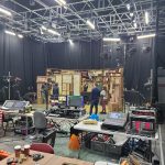 A busy TV studio with a set and technical equipment