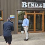 Filming on Location. Pete holds a gimbal, filming an employee