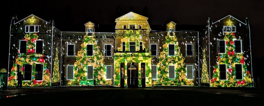 Hestercombe house at night. Front view of christmas trees being projected onto Hestercombe house at night as part of the mapped display.