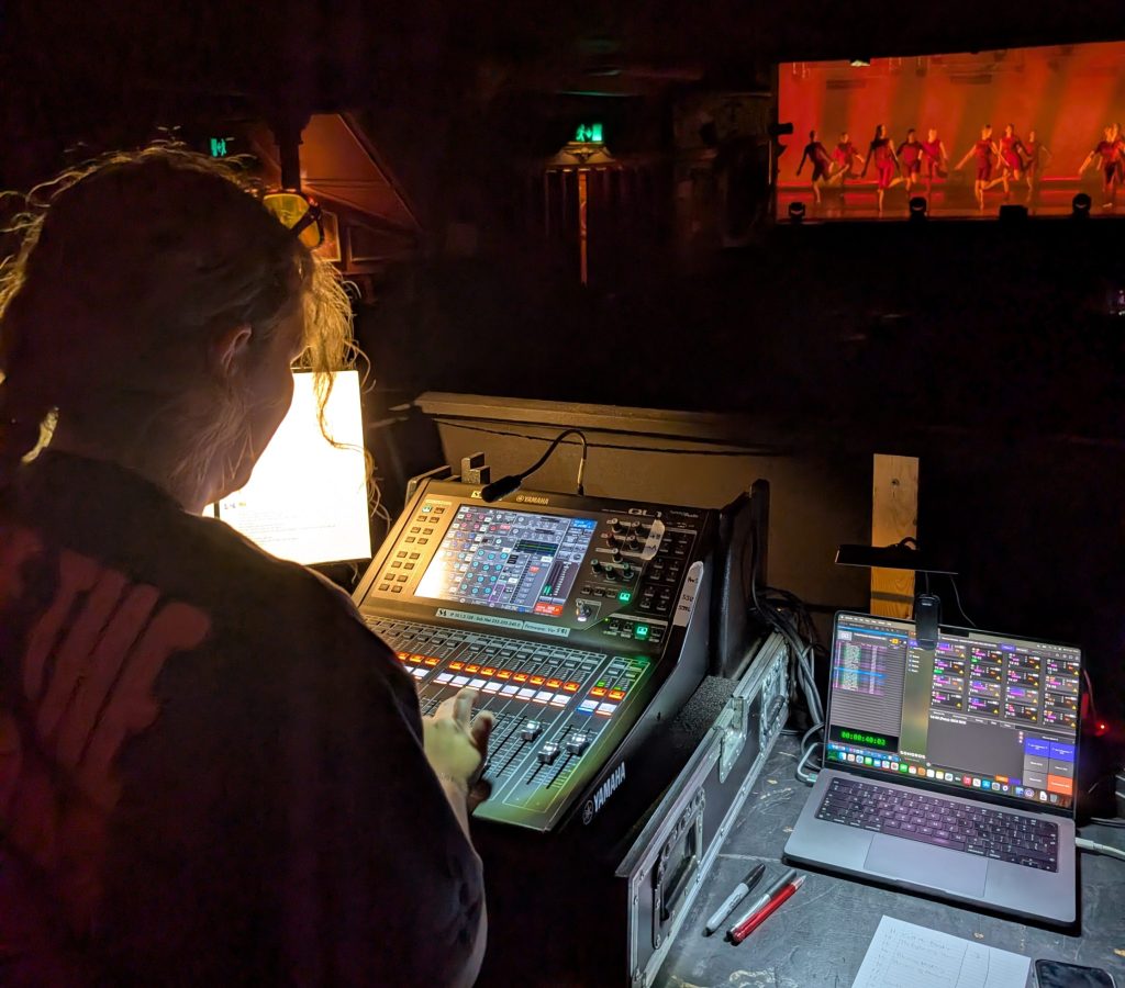 Lizzie operating the sound desk during a show
